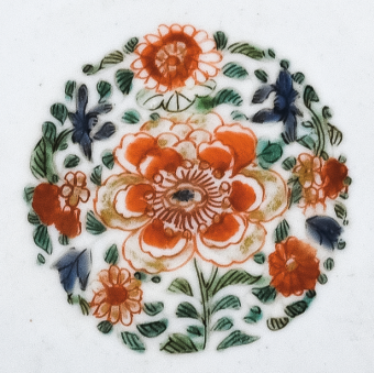 圖為清代五彩花卉紋碟細節(jié)圖，碟心主題紋飾為團花圖，紅花綠葉，相映成趣。（來源：廣州十三行博物館）